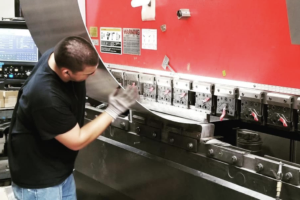 Worker performing CNC sheet metal machining